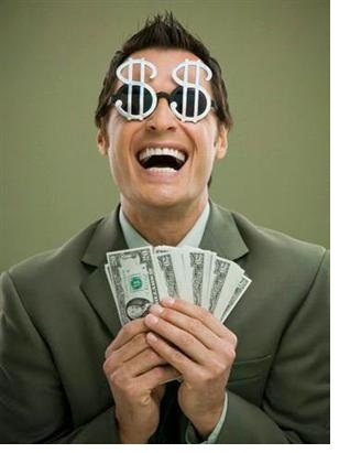 A laughing man wearing sunglasses with dollar signs holding many $20 bills.