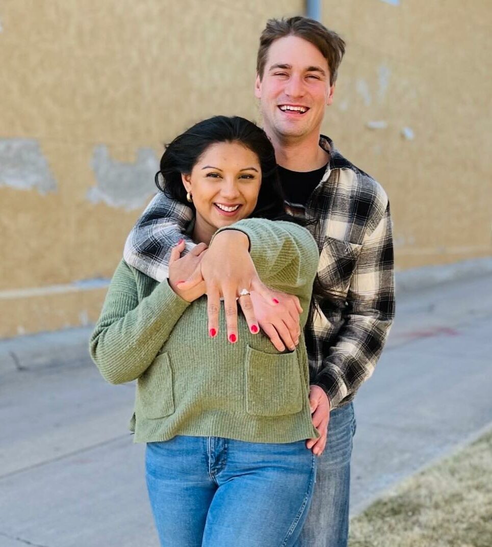 Happy couple smile as she shows off engagement ring purchased at Nebraska Diamond.