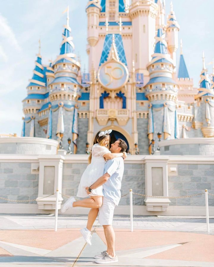 Happy couple embraces in front of castle.